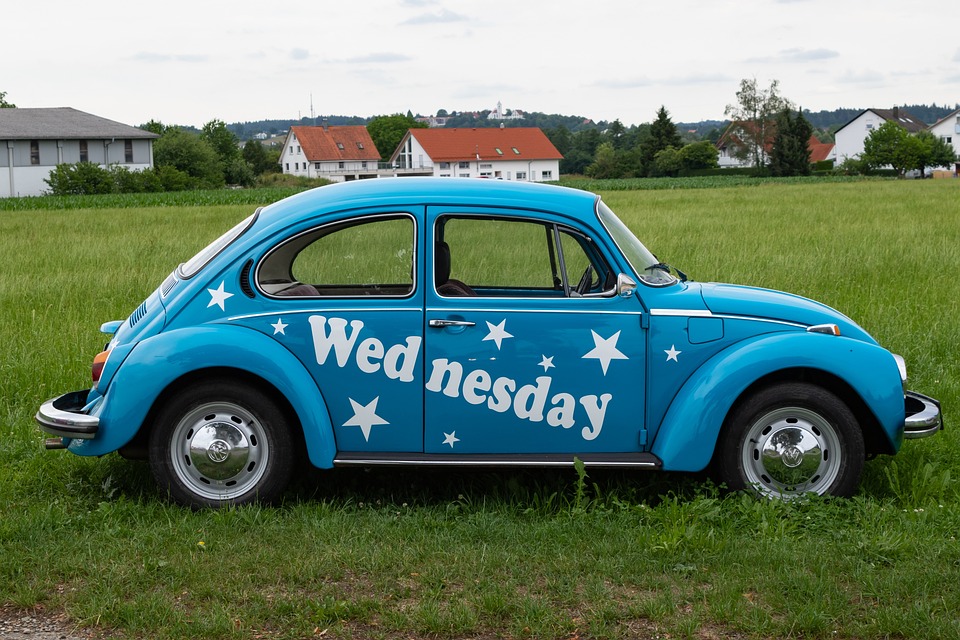 A blue Volkswagen Beetle with the word "Wednesday" on the side.